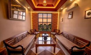 a room with benches and a table and a window at Hotel Gems Suites in Jaipur