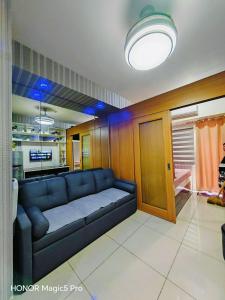 a living room with a blue couch in a room at Shell Residences MOA&NAIA by-Sandy in Manila