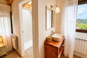 a bathroom with a sink and a mirror and a window at La Casina de San Pedro Ribadesella in Ribadesella +13 photos