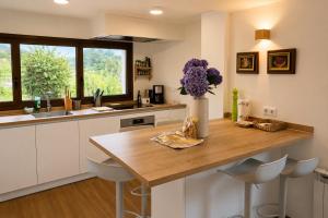 a kitchen with a table and a vase of purple flowers at La Casina de San Pedro Ribadesella in Ribadesella