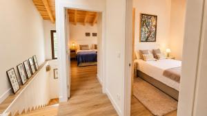 a bedroom with two beds and a hallway at La Casina de San Pedro Ribadesella in Ribadesella