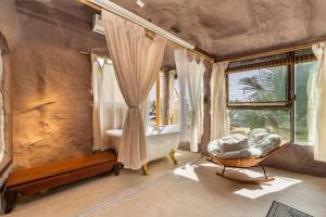 a bedroom with a tub and a bed and a window at OXY Cave Homestay Mũi Né in Mui Ne +36 photos