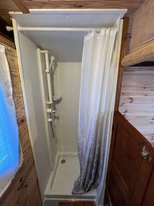 a shower in an rv bathroom with a shower curtain at roulotte les sabots d Helene in Cruzilles-lès-Mépillat