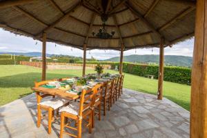 a wooden table and chairs under a wooden umbrella at La Pietraia by VacaVilla in Poppi