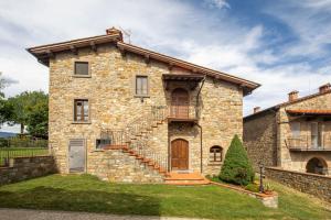 a large stone house with a staircase in front of it at La Pietraia by VacaVilla in Poppi +44 photos