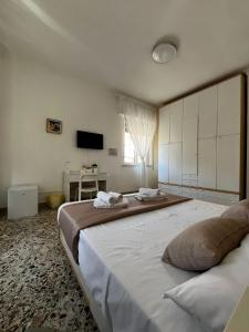 a bedroom with a large bed and a television at Pellegrino House in Palermo