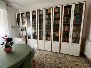 a large library with white cabinets and books at Pellegrino House in Palermo