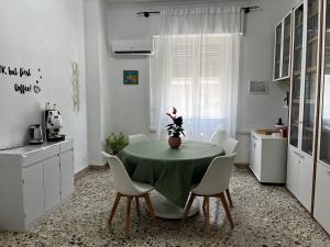 a kitchen with a green table and white chairs at Pellegrino House in Palermo