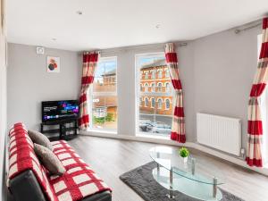 a living room with a couch and a glass table at Dainty Curve in Kettering