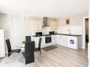 a kitchen and dining room with a table and chairs at Dainty Curve in Kettering