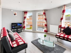 a living room with a couch and a glass table at Dainty Curve in Kettering