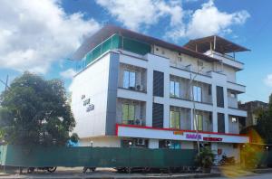 a white building with a green fence in front of it at Hotel Sagar Residency in Panvel