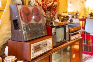 three old microwaves and a tv on a table at OXY Cave Homestay Mũi Né in Mui Ne
