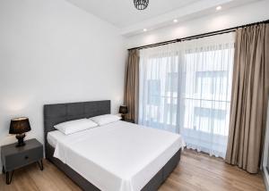 a bedroom with a white bed and a large window at Aqualina C3-4 by HolidayKeys in Kyrenia +14 photos