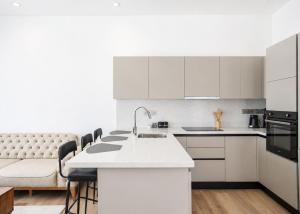 a kitchen with white cabinets and a kitchen island at Aqualina C3-4 by HolidayKeys in Kyrenia