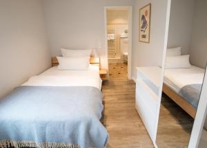 two beds in a small room with a mirror at Hotel Seehof Norderney OHG in Norderney +104 photos