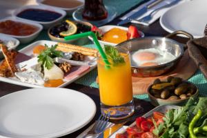 a table with plates of food and a glass of orange juice at Adasya Hotel in Kaş