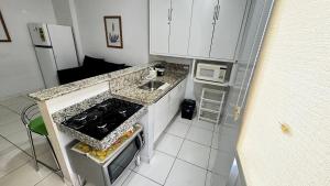 a small kitchen with a stove and a sink at CRCN - Golden Dolphin Grand Hotel in Caldas Novas