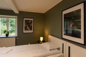 a bedroom with a bed with green walls and a picture at Nordic Lodges in Malmö