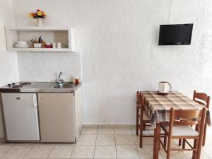 una cucina con un tavolo e un lavello e un tavolo e sedie di Haniotis Studios a Faliraki