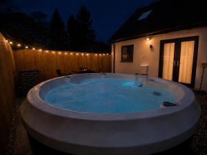a large hot tub in a backyard at night at Hawthorn Cottage in Tenby