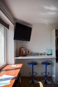 a kitchen with two blue bar stools and a counter at L'atelier de Mathieu meublés de tourisme classés in Saint-Rémy-sur-Durolle