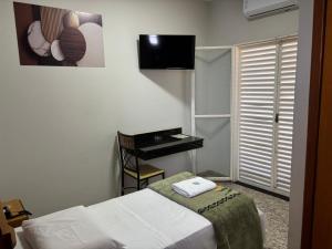 a hotel room with a bed and a desk at Diplomata Hotel in Sertãozinho