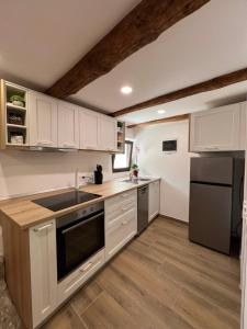 a kitchen with white cabinets and a black appliance at Pr'Tončih in Podgorje +3 photos