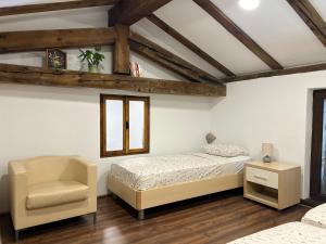 a bedroom with a bed and a chair at Pr'Tončih in Podgorje