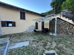 a house with a table and chairs in front of it at Pr'Tončih in Podgorje