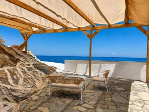 a tent with two chairs and a view of the ocean at Kofinas villa Evdilos by BRP-PROPERTIES in Evdilos