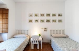 two beds in a room with a table and a chair at Between sea and Altafulla castle in Altafulla