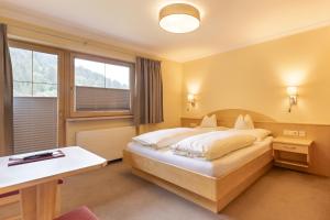 a hotel room with a bed and a window at Haus Tirol in Tux