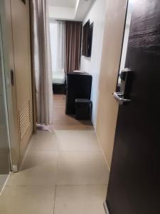 a hallway of a hotel room with a door open at Staycationbabe in Manila