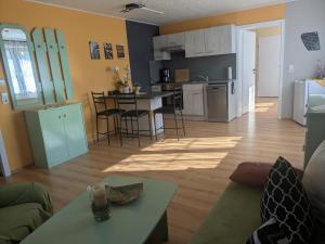 a living room and kitchen with a couch and a table at Ferienwohnung Am Apelsberg in Neuhaus am Rennweg +17 photos
