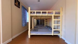 two bunk beds in a room with a staircase at Buku Island House in san juan la union