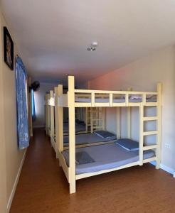 a bunk bed room with three bunk beds in it at Buku Island House in san juan la union