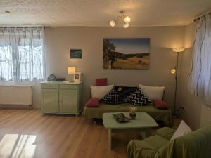 a living room with a couch and a table at Ferienwohnung Am Apelsberg in Neuhaus am Rennweg