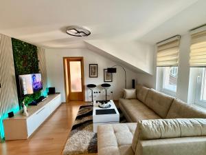 a living room with a couch and a tv at Lambada Penthouse in Bugojno