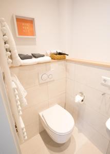 a white bathroom with a toilet and a sink at Hotel Seehof Norderney OHG in Norderney