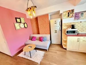 a living room with a couch and a kitchen at Apartament Centru Plaja Modern in Constanţa