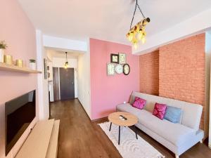 a living room with a couch and a brick wall at Apartament Centru Plaja Modern in Constanţa