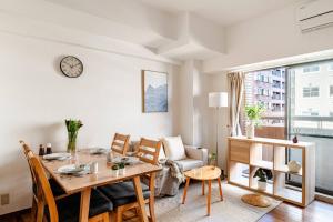 a living room with a table and chairs and a dining room at Cozy Japandi 3LDK in Namba for Groups in Osaka