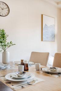 a dining room table with a clock on the wall at Cozy Japandi 3LDK in Namba for Groups in Osaka +5 photos