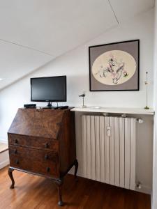 a television on top of a dresser in a room at Casa Olgaluna - Art Home in La Spezia