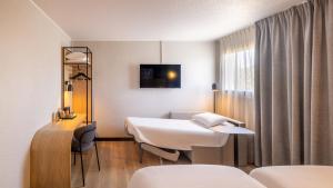 a hospital room with a bed and a desk at Campanile PRIME - Paris Bobigny in Bobigny