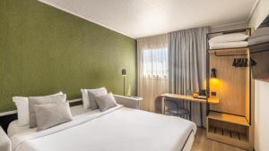a hotel room with a bed and a desk at Campanile PRIME - Paris Bobigny in Bobigny +54 photos