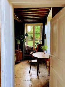 a dining room with a table and a window at Les Prés du Manoir in Le Manoir