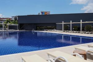 a large swimming pool with chairs and a building at Four Points Flex by Sheraton Bursa Nilüfer in Bursa