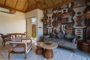 a living room with a couch and a table at ENVI Paje Wellness Lodge in Paje